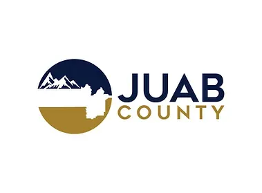 The logo for juab county is blue and gold with mountains in the background.