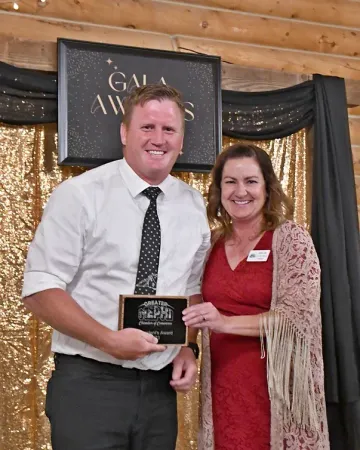A man and woman are posing for a picture in front of a sign that says gala awards
