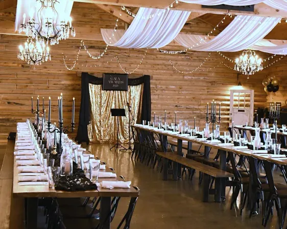 A large room with tables and chairs set up for a wedding reception.