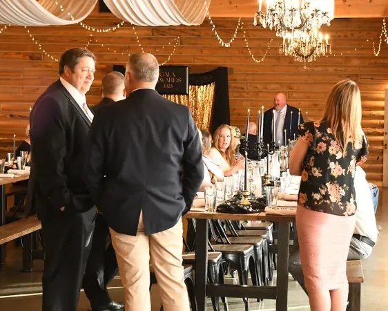 A group of people are standing around a table in a room.