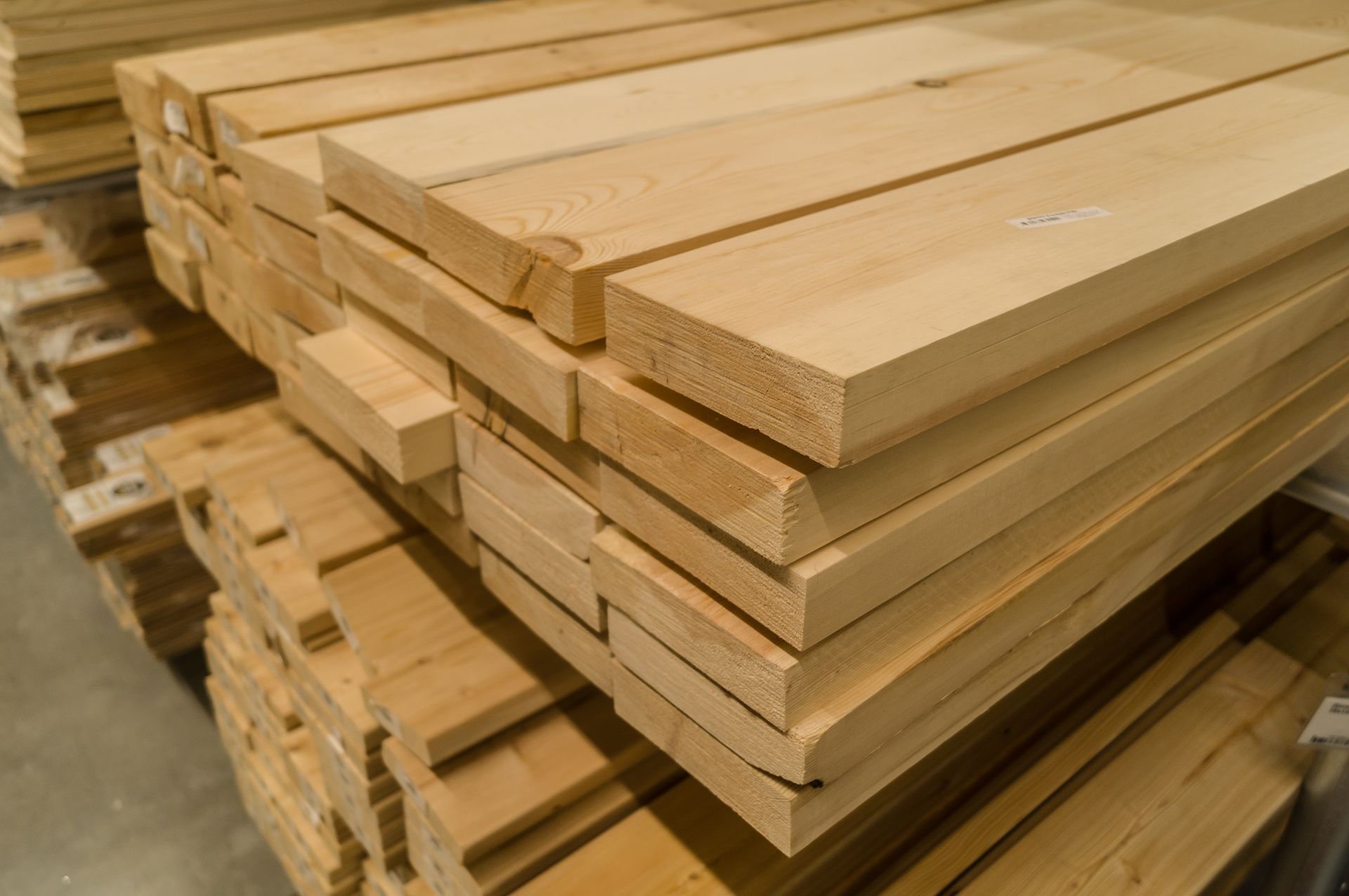 Una pila di assi di legno adagiate una sull'altra in un magazzino.