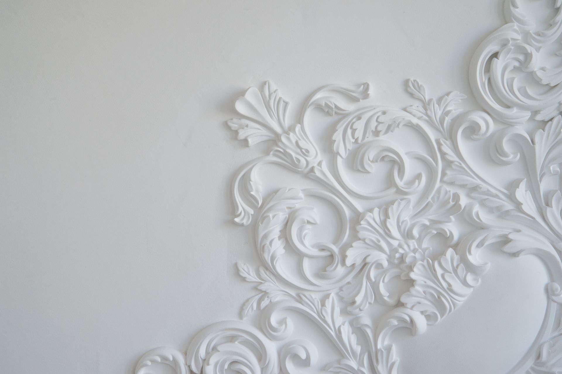Un primo piano di un muro bianco con un disegno floreale.