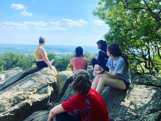A group of people are sitting on top of a rock.