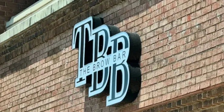 Black-and-white “The P” sign mounted on a brick wall exterior