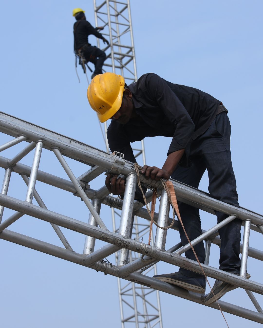 A man is welding a piece of metal in a factory.
