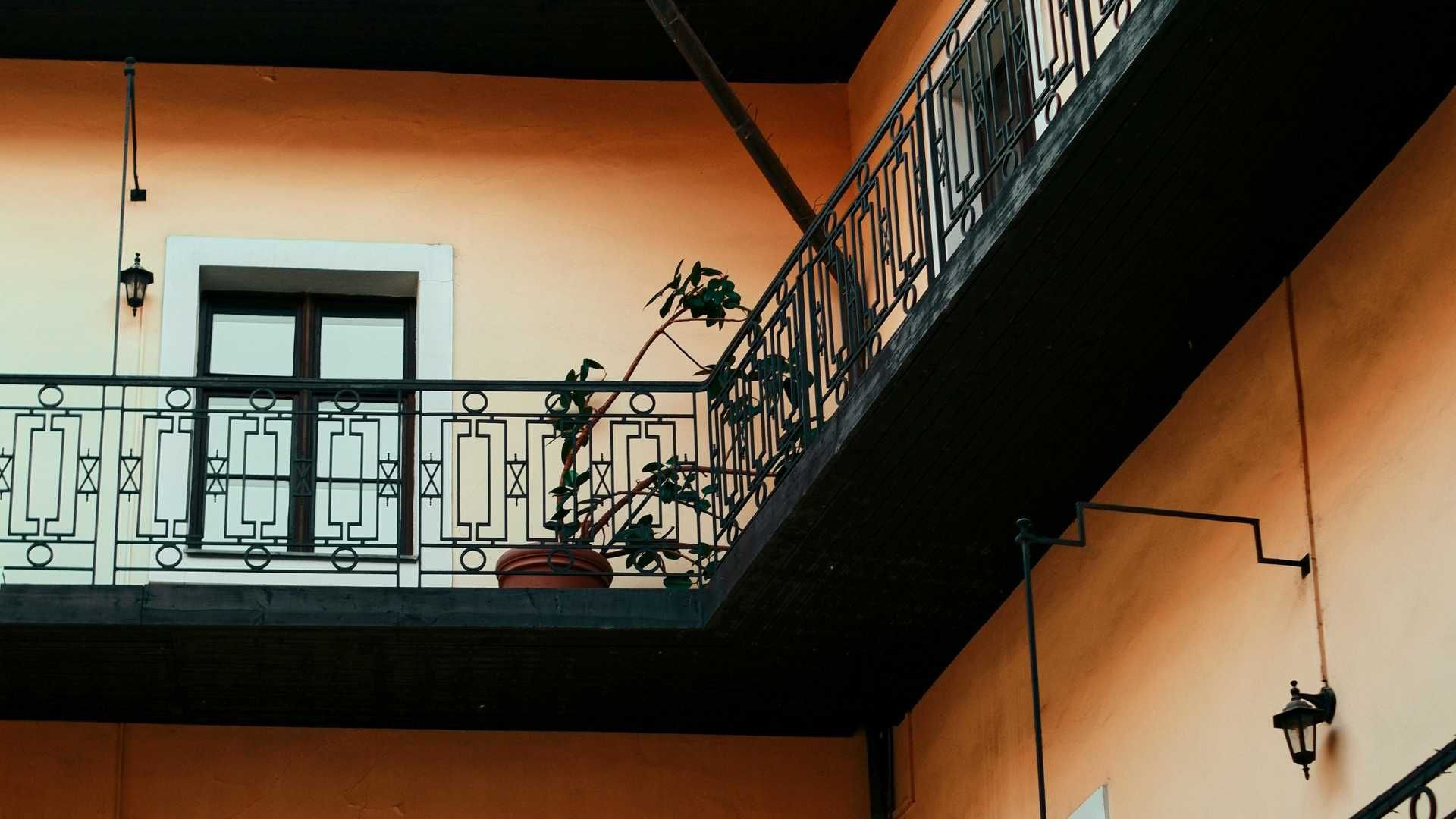 A balcony with a wrought iron railing on the side of a building.