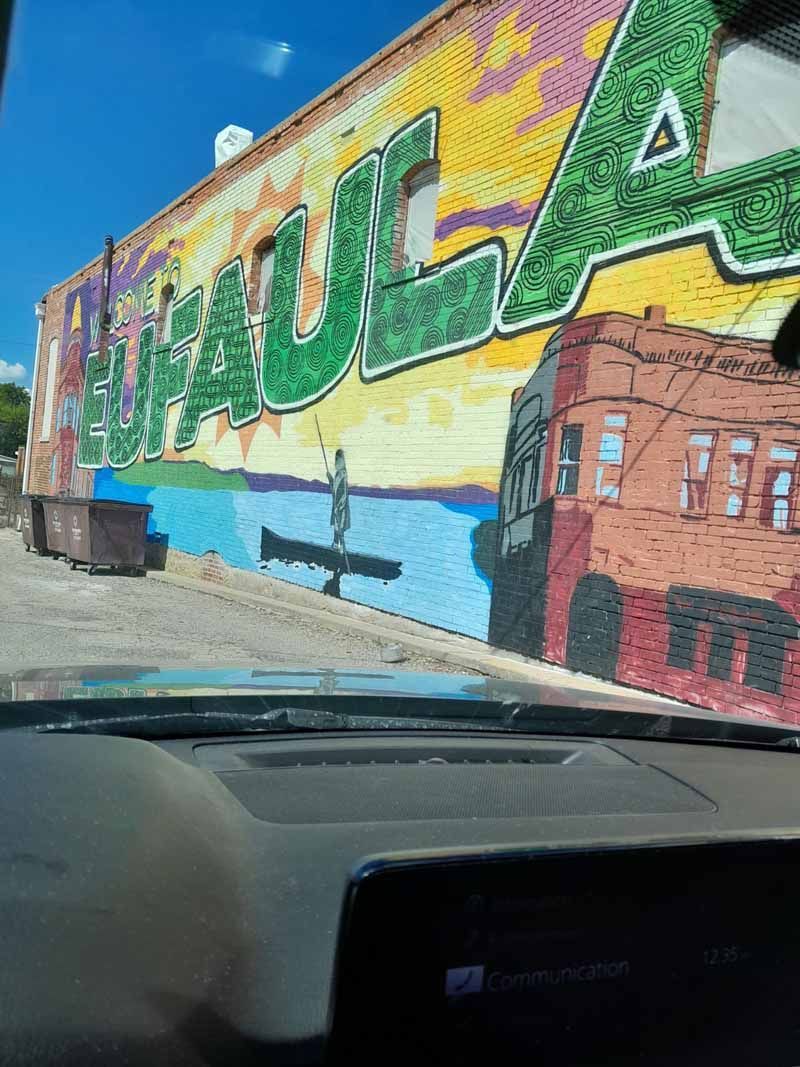 Colorful mural on brick building, with words 