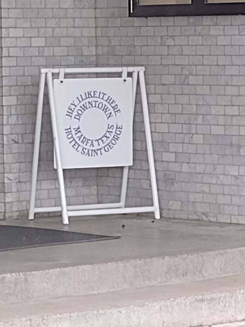 White sign on a frame outside, text: 