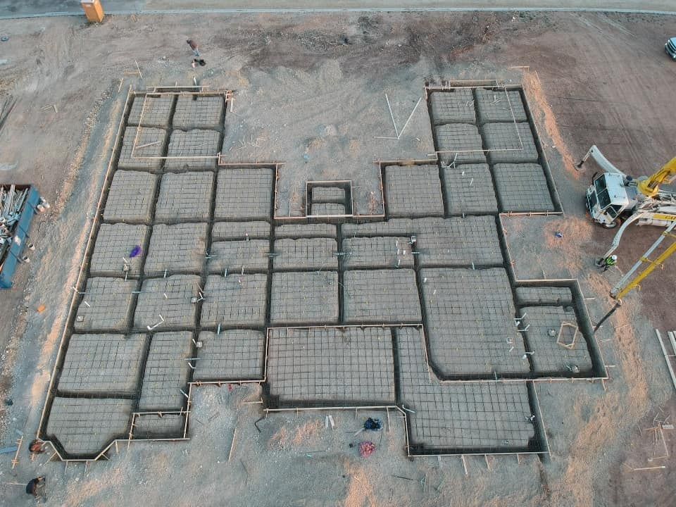 Aerial view of a construction site with concrete foundation forms.