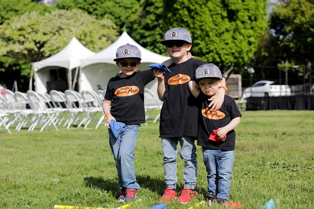 Three young boys link arms and smile at The Walk to Make Cystic Fibrosis History.