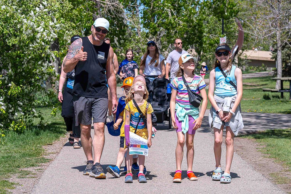 A father and his three daughters stroll outside along the Walk route at The Walk to Make Cystic Fibrosis History.