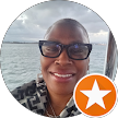Person with glasses smiles on a boat, ocean background, star icon.