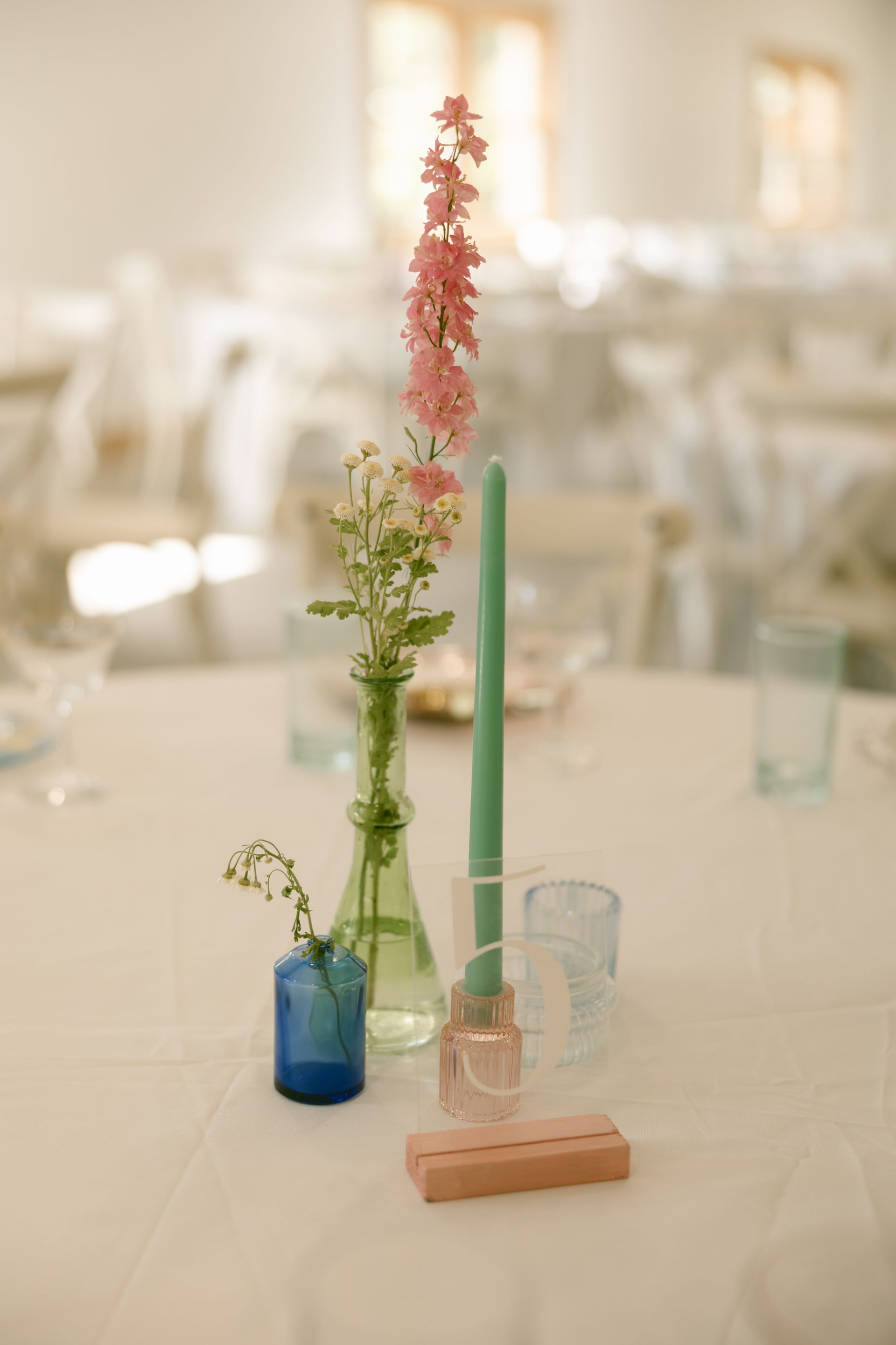 A table with a vase of flowers and candles on it.