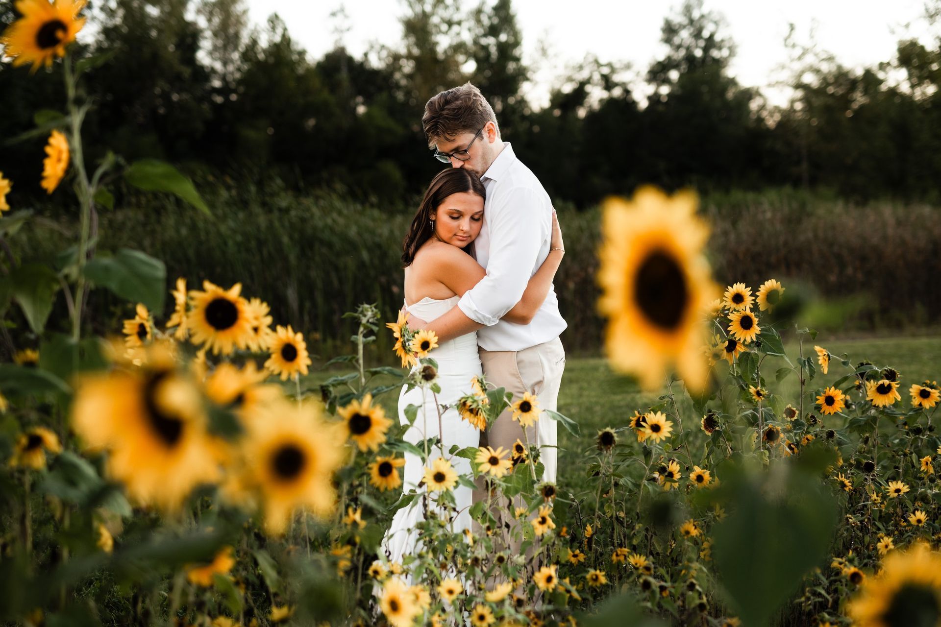 bride and groom hugging outdoors next to sunflowers at the outdoor wedding venue in Marion, IN, The Covenant Place.