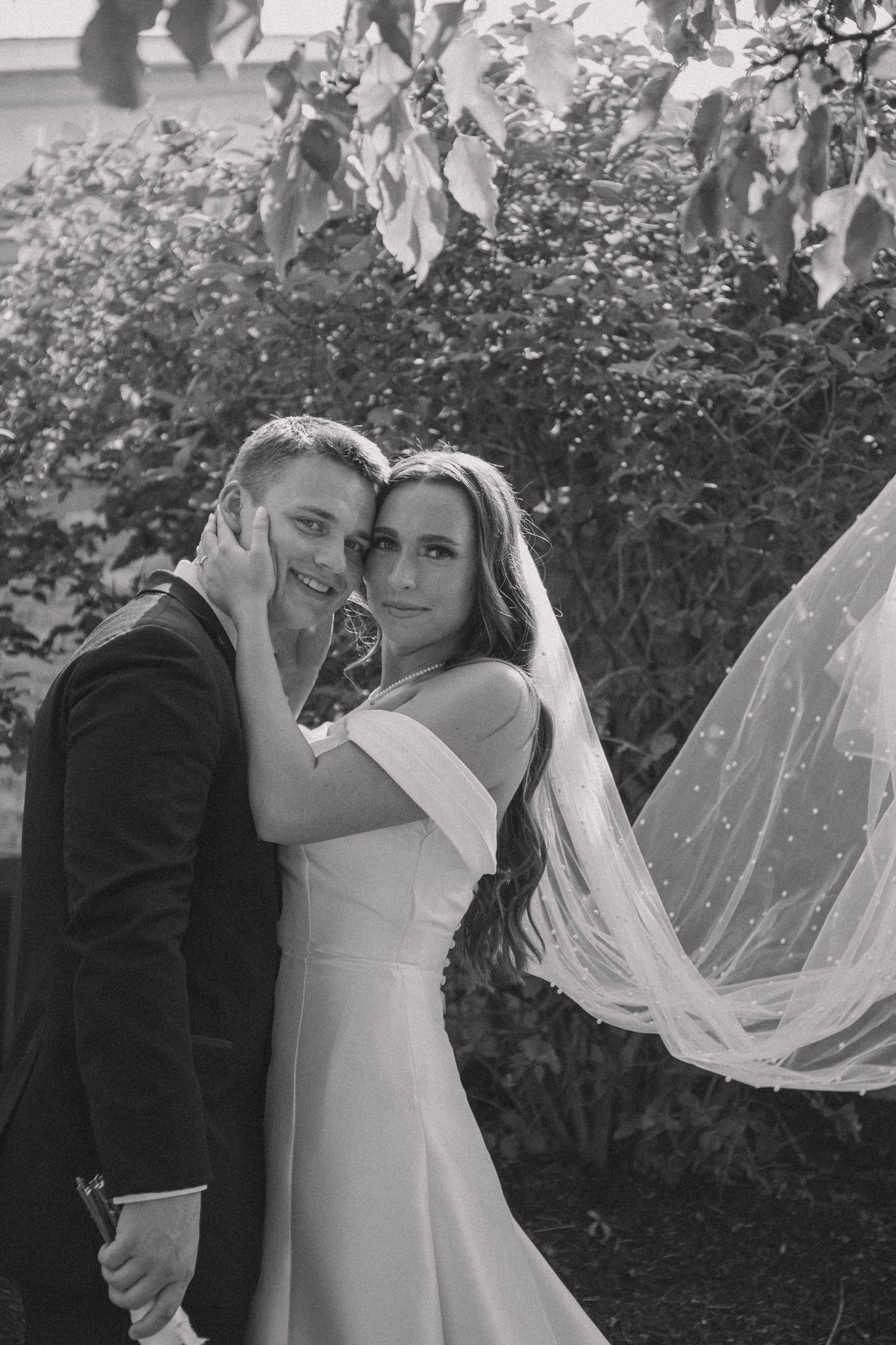 A black and white photo of a bride and groom posing for a picture.
