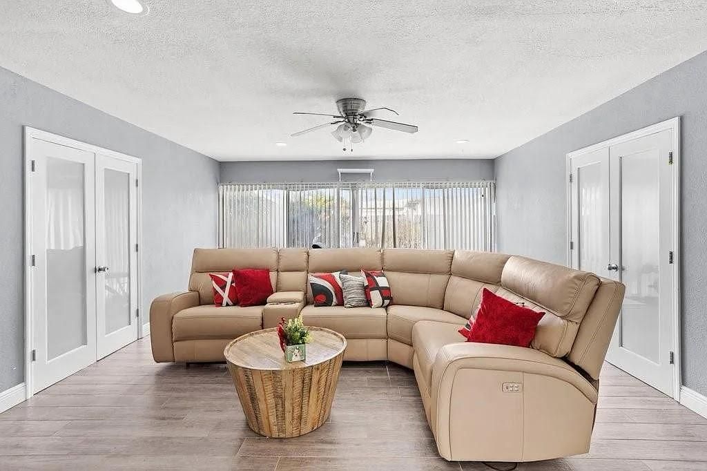 A woman is kneeling on the floor cleaning the floor in a living room.