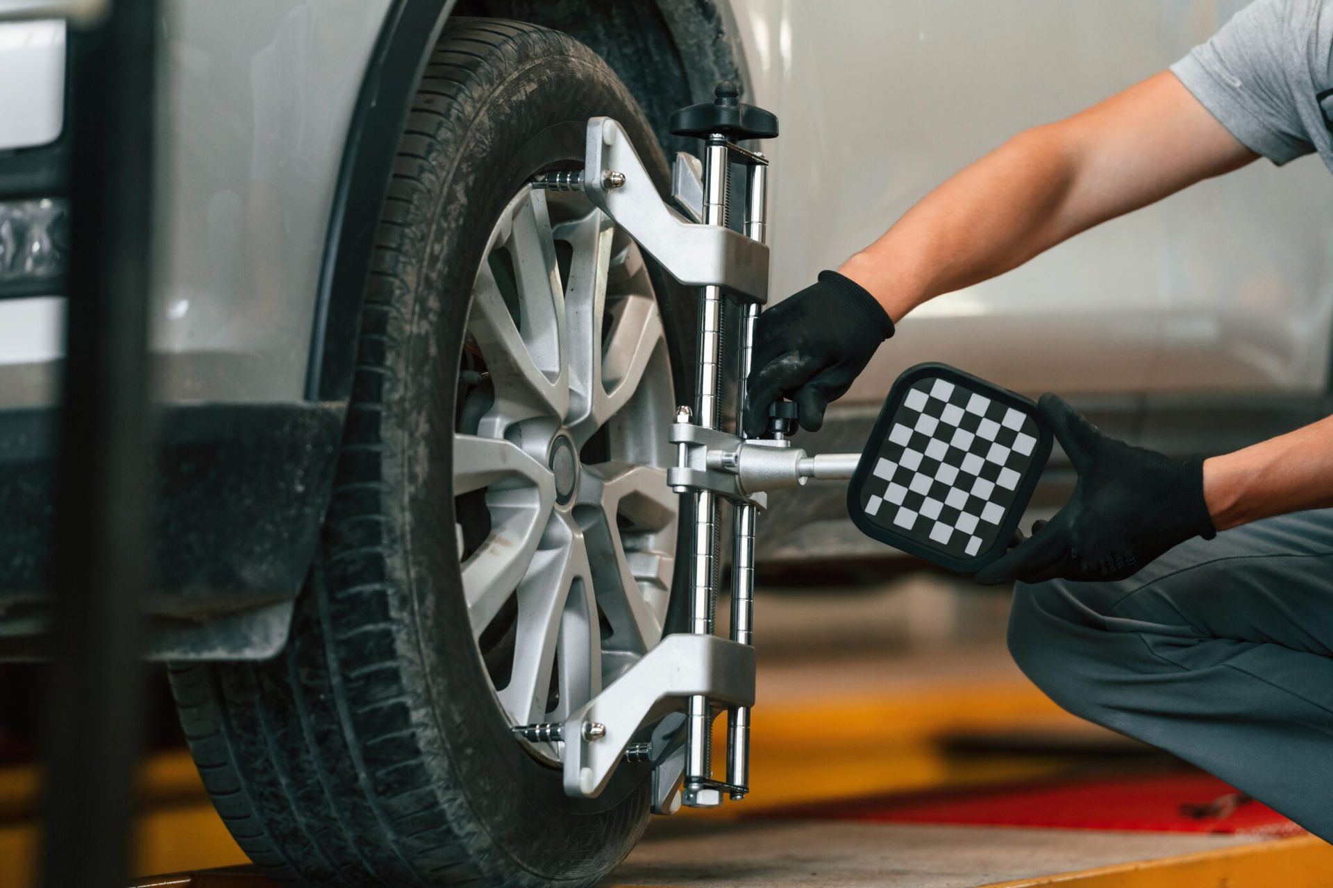 Mechanic using a wrench to change a car tire in a garage
