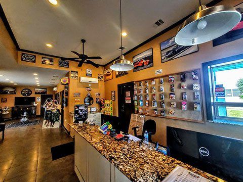 Cozy bar interior with polished wood counter, wall photos, hanging lights, and bright windows