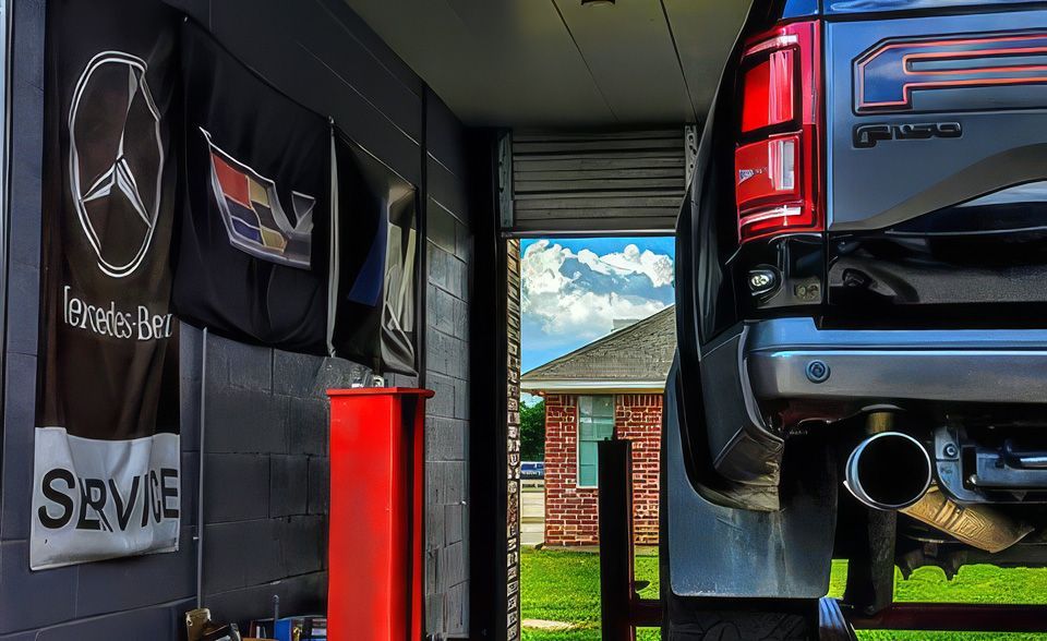 Garage scene with a black SUV on a lift and Mercedes-Benz banners on the wall
