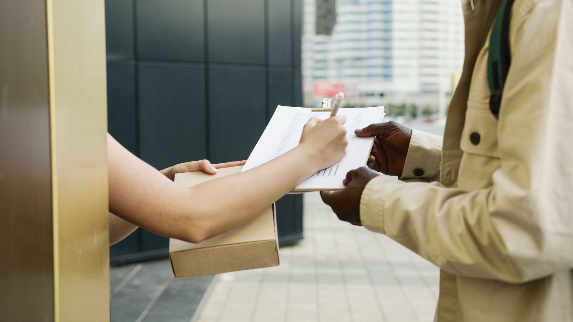 Hands exchanging a document at a service counter in an office lobby
