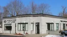 Single-story medical office building with large windows and signs, seen on a sunny day