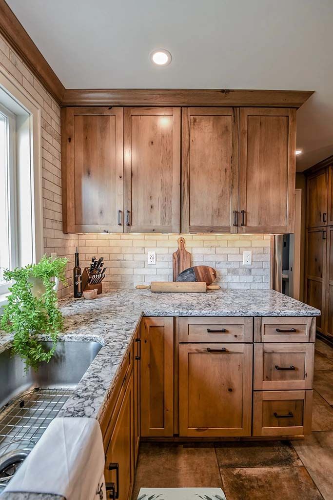 A kitchen with black cabinets and stools and a large island.