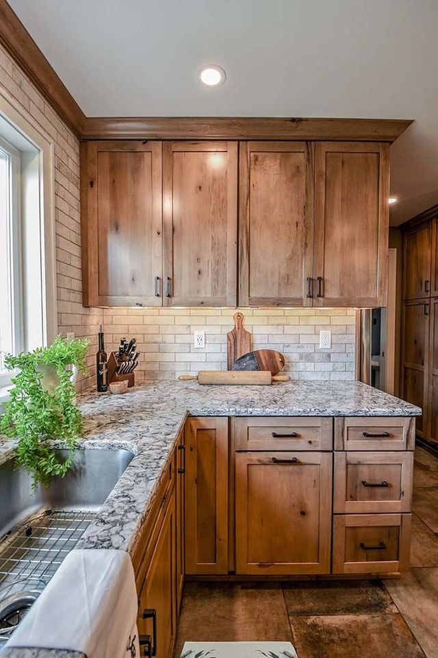 A kitchen with black cabinets and stools and a large island.