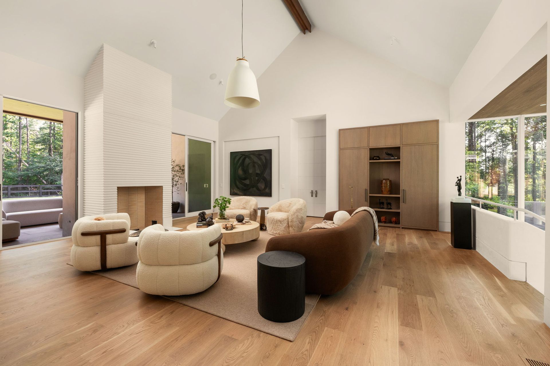 Vaulted living room with bouclé furniture and stone fireplace