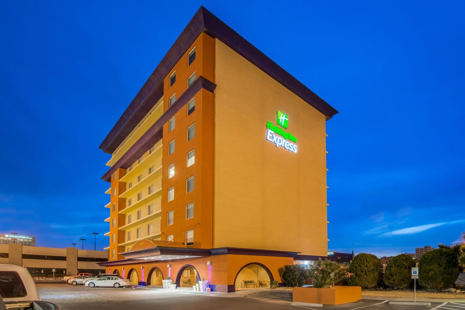 Holiday Inn Express hotel building with orange and brown facade against a blue sky.