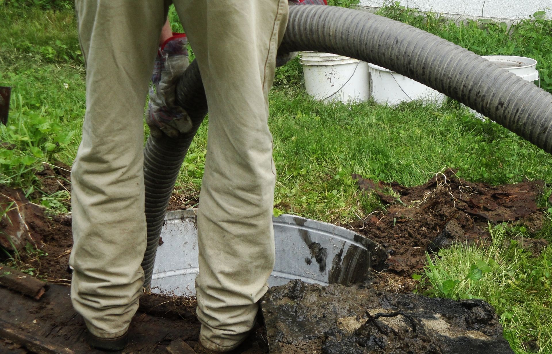 A contractor performing a septic pumping service with specialized equipment on a home.