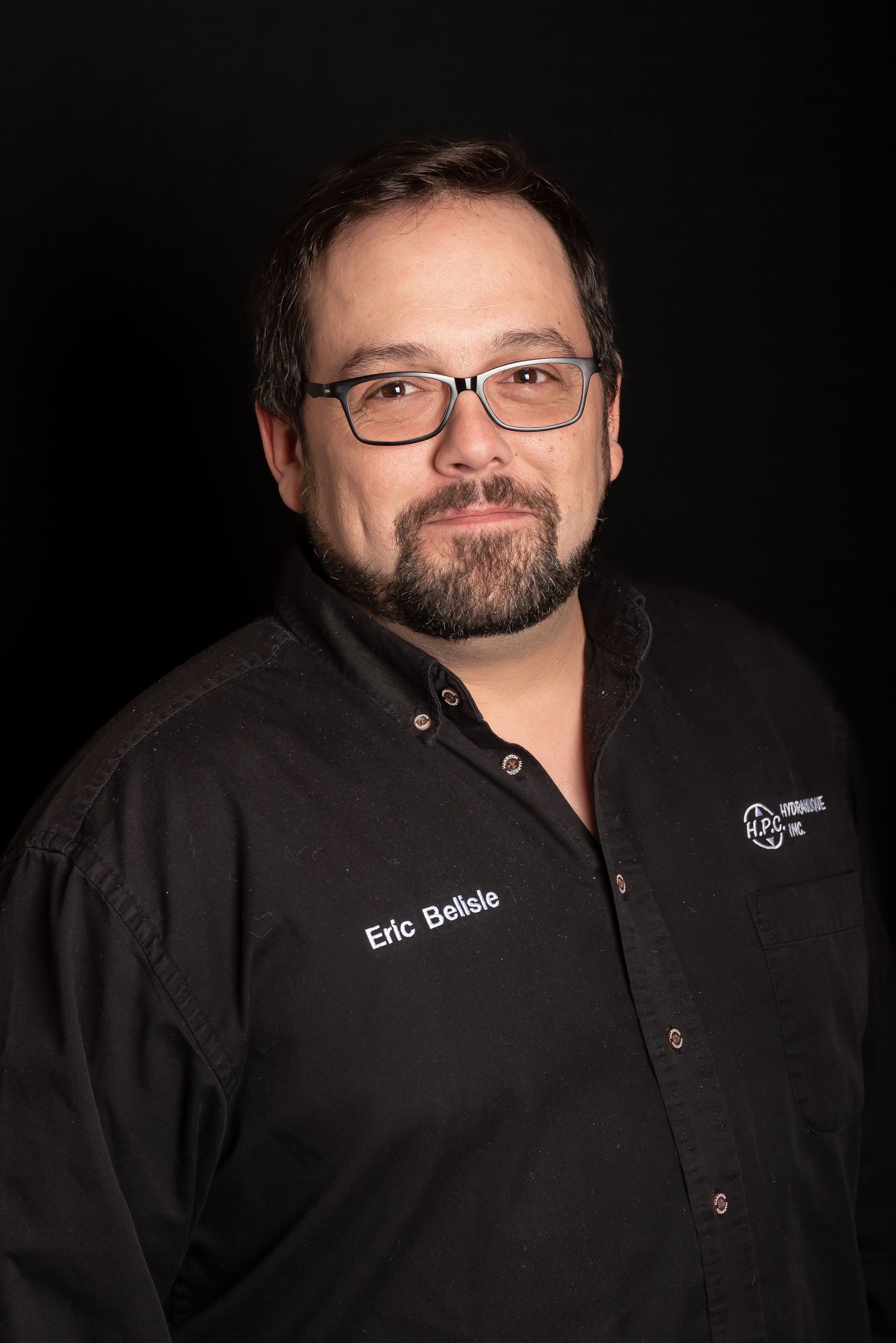 Man with glasses, goatee, in black shirt, name tag says