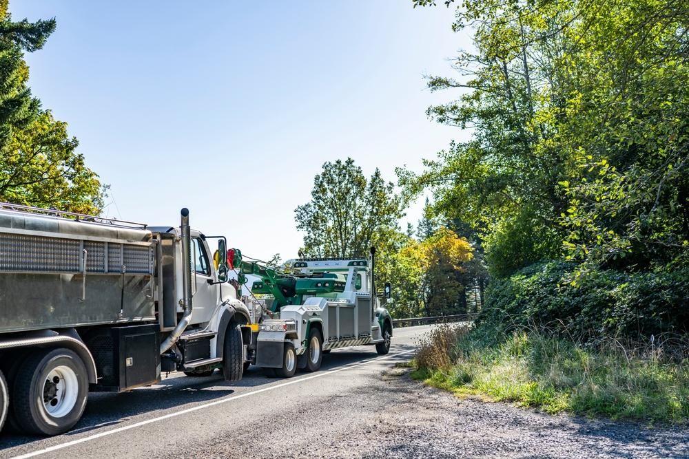 Two Dump Trucks Are Parked on the Side of the Road — DJ's Tilt Tray Service in Nambucca Heads, NSW