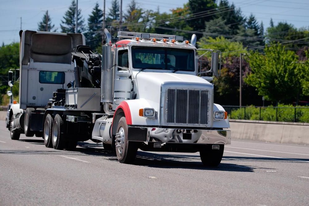 Two Semi Trucks Are Driving Down a Highway Next to Each Other — DJ's Tilt Tray Service in Coffs Harbour, NSW