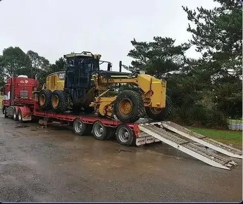 A Bulldozer is Being Transported on a Trailer With Ramps — DJ's Tilt Tray Service in Coffs Harbour, NSW