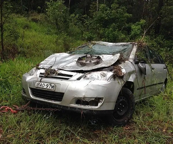 A Silver Car Has Crashed Into a Tree in the Grass — DJ's Tilt Tray Service in Bellingen, NSW