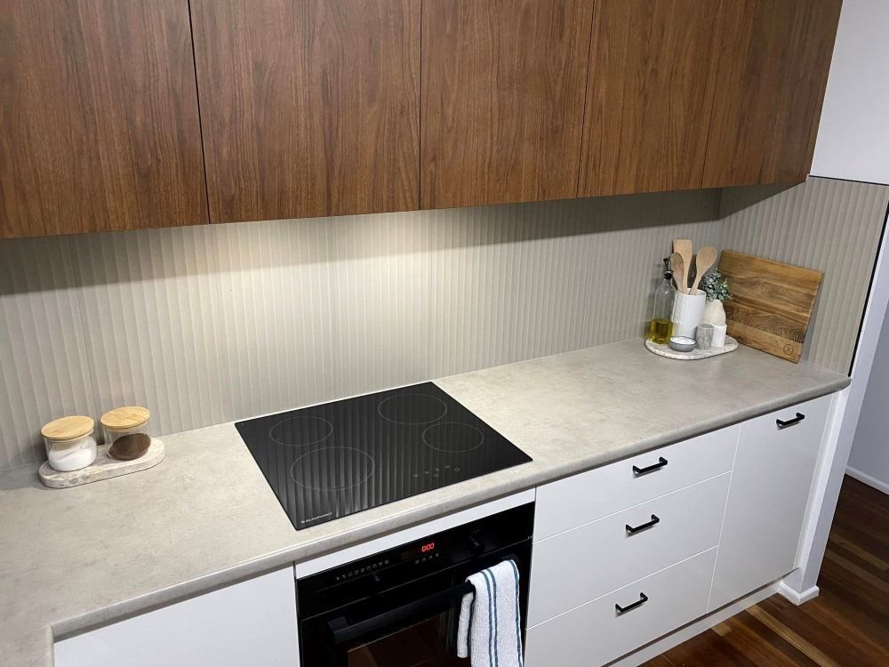A Kitchen With A Black Stove Top Oven , White Cabinets , And Wooden Cabinets — O'Donnell Cabinetmaking in Kawana, QLD