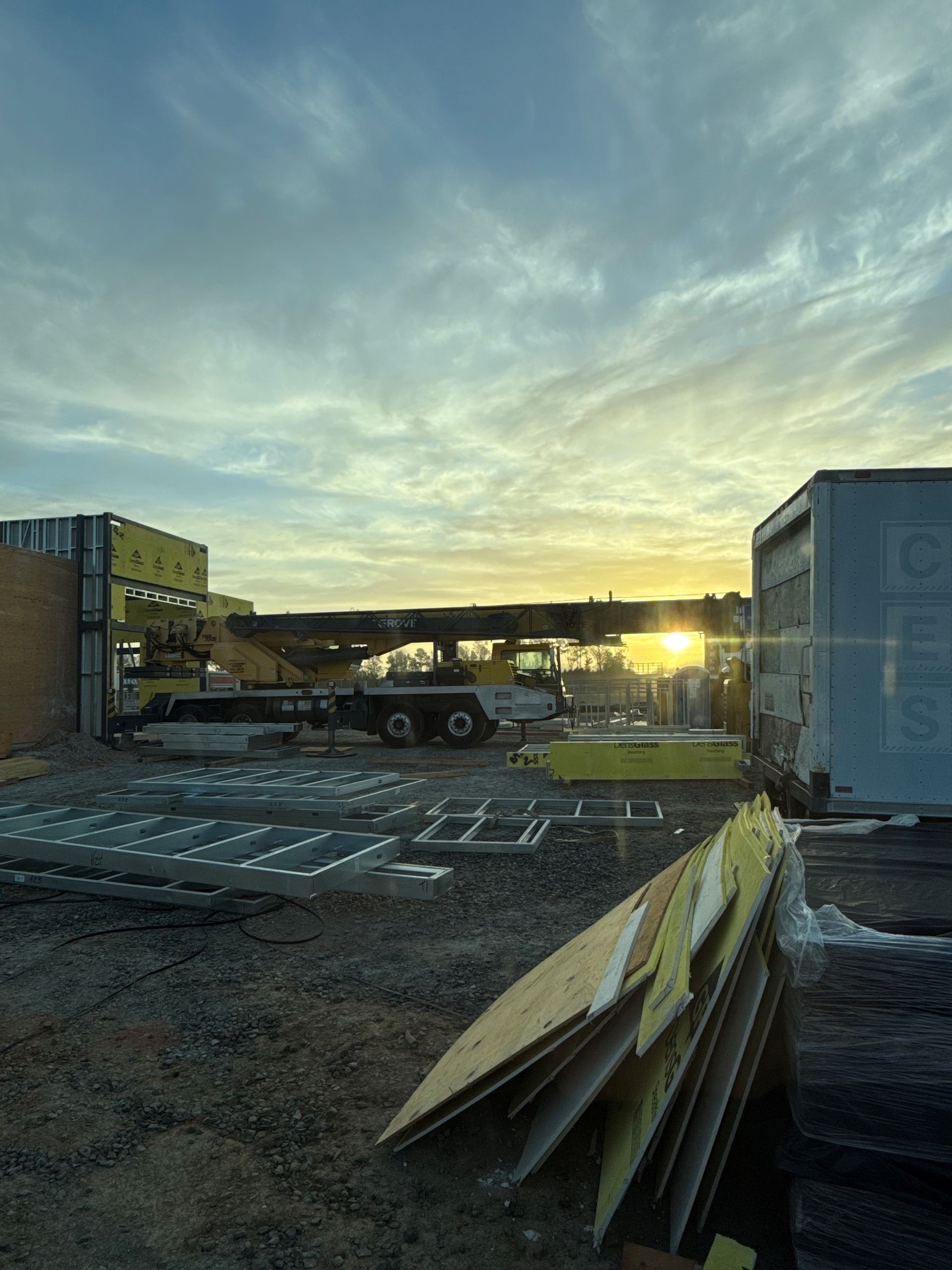 A construction site with a truck and a crane in the background at sunset. — Fayetteville, NC — Bill's Mobile Crane Service