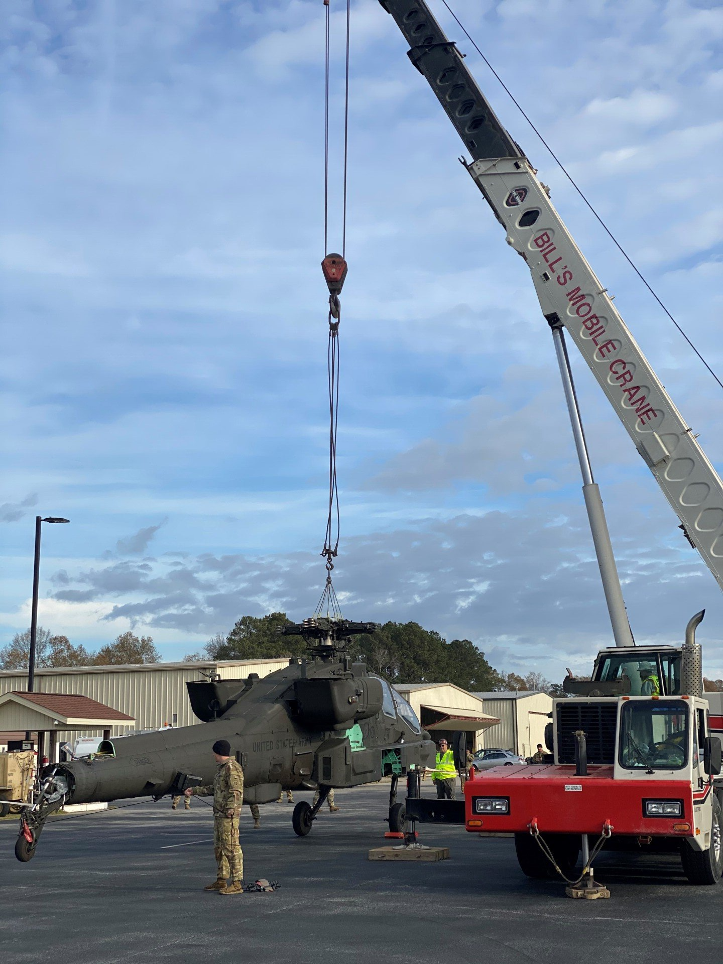A helicopter is being lifted by a large crane. — Fayetteville, NC — Bill's Mobile Crane Service