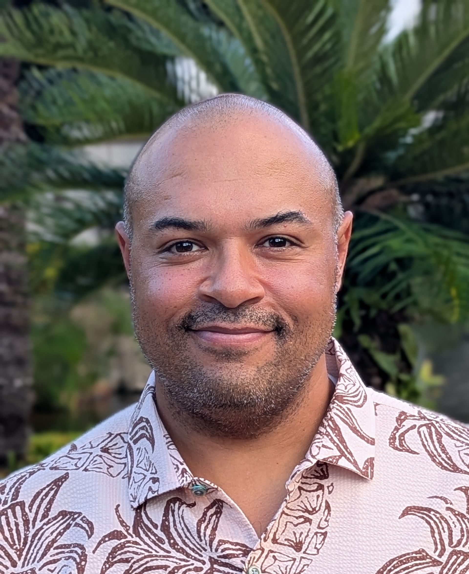 A man in a suit and white shirt is smiling for the camera.