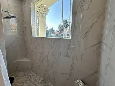 A bathroom with a walk in shower and a window.