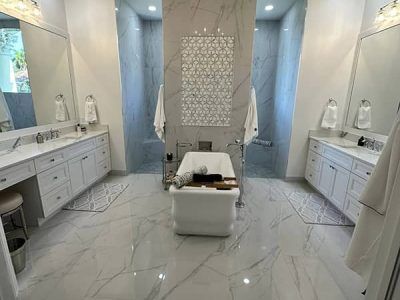 A bathroom with two sinks , a tub , and a walk in shower.