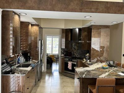 A kitchen with stainless steel appliances , granite counter tops , and wooden cabinets.