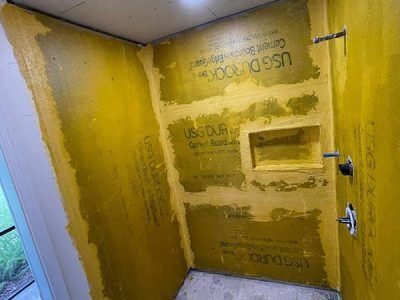 A bathroom with yellow walls and a shower stall.
