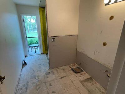 A bathroom under construction with a tiled floor and a door.