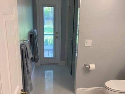 A bathroom with a toilet , towels , and a door.