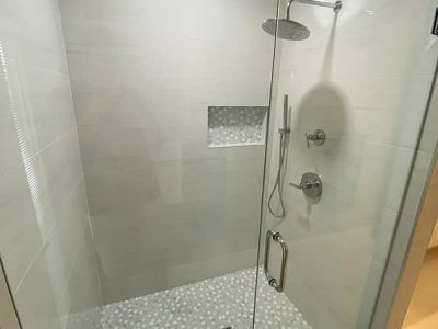 A shower with a glass door and a shower head.