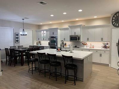 A large kitchen with a large island and a clock on the wall.