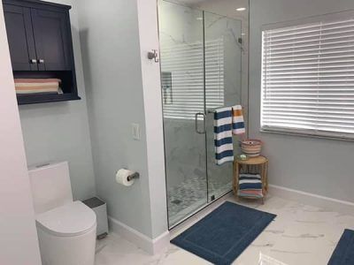 A bathroom with a toilet , shower , and window.