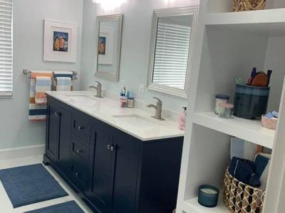 A bathroom with two sinks , two mirrors and a shelf.