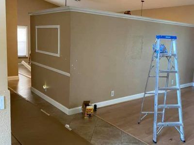 A ladder is sitting in the middle of a room next to a wall.